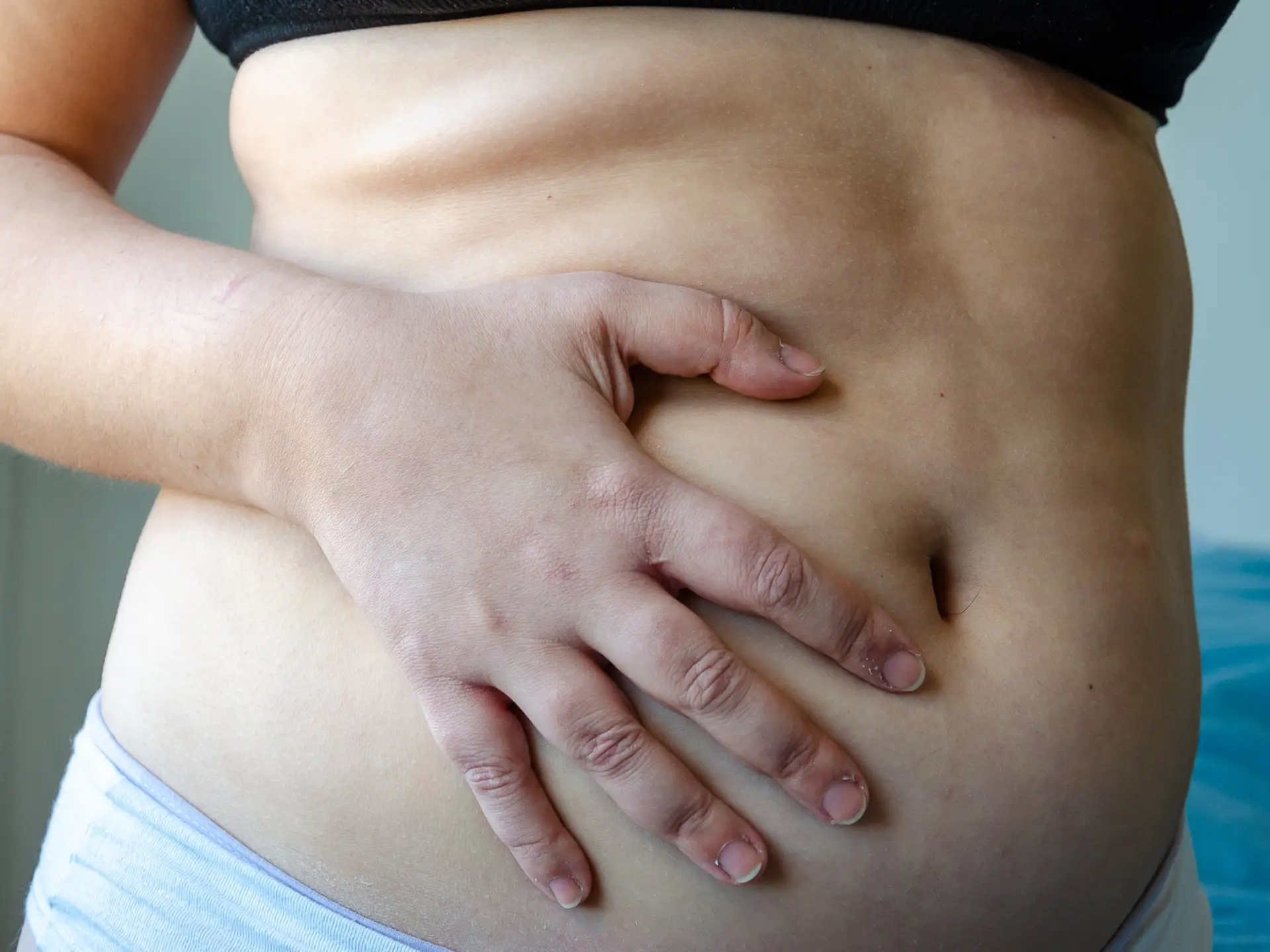 closeup on woman belly, overweight adiposity, fat, real body, seen by side