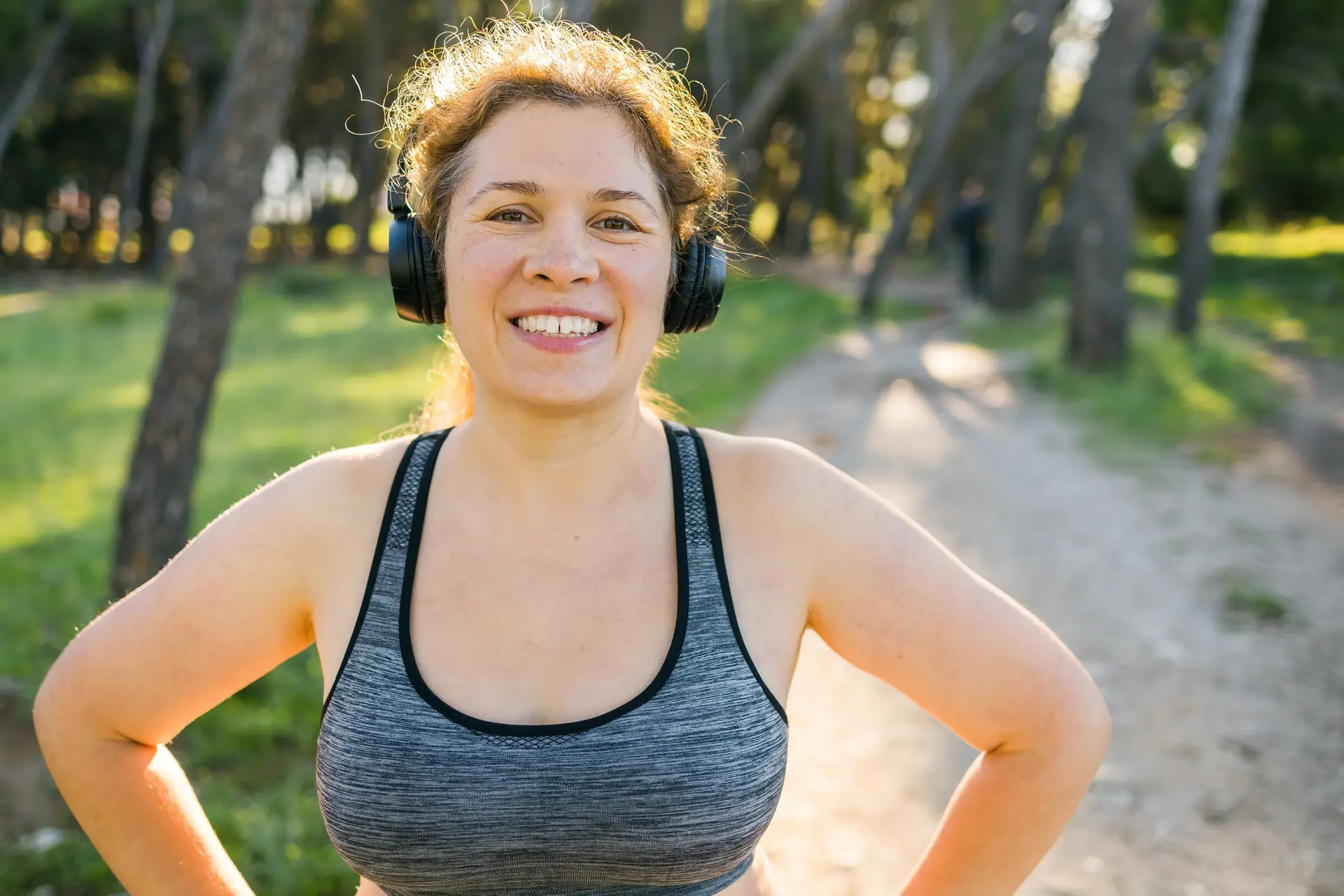 Fat woman and sports. Girl doing exercise for weight loss in the fresh air and laughing in camera